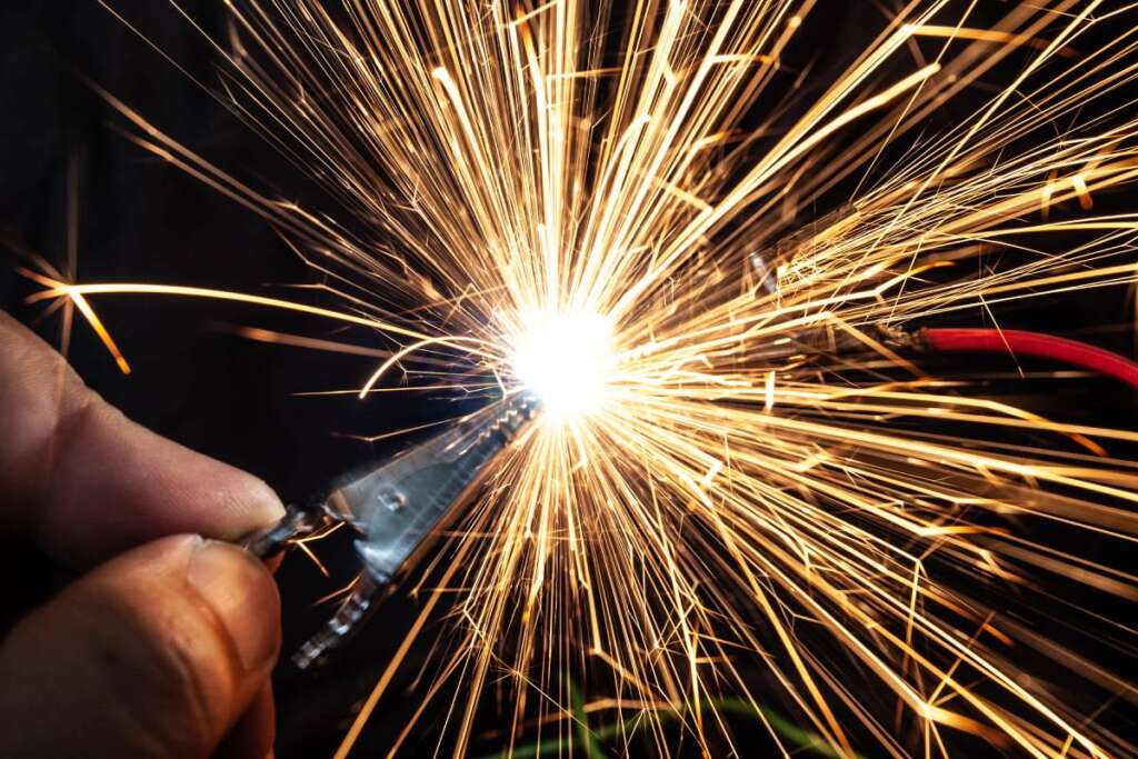 Bright burning sparks fly from incorrectly closed contacts. The concept of danger of electric shock and safety.