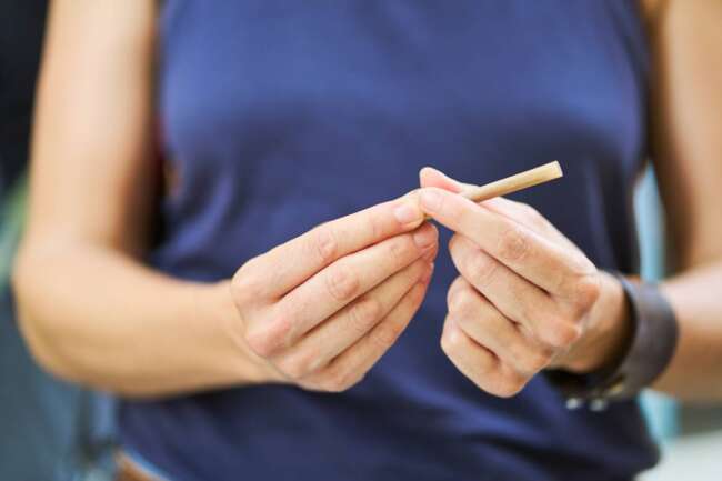 unrecognizable adult woman rolling cigarette for therapeutic purposes and medical treatment