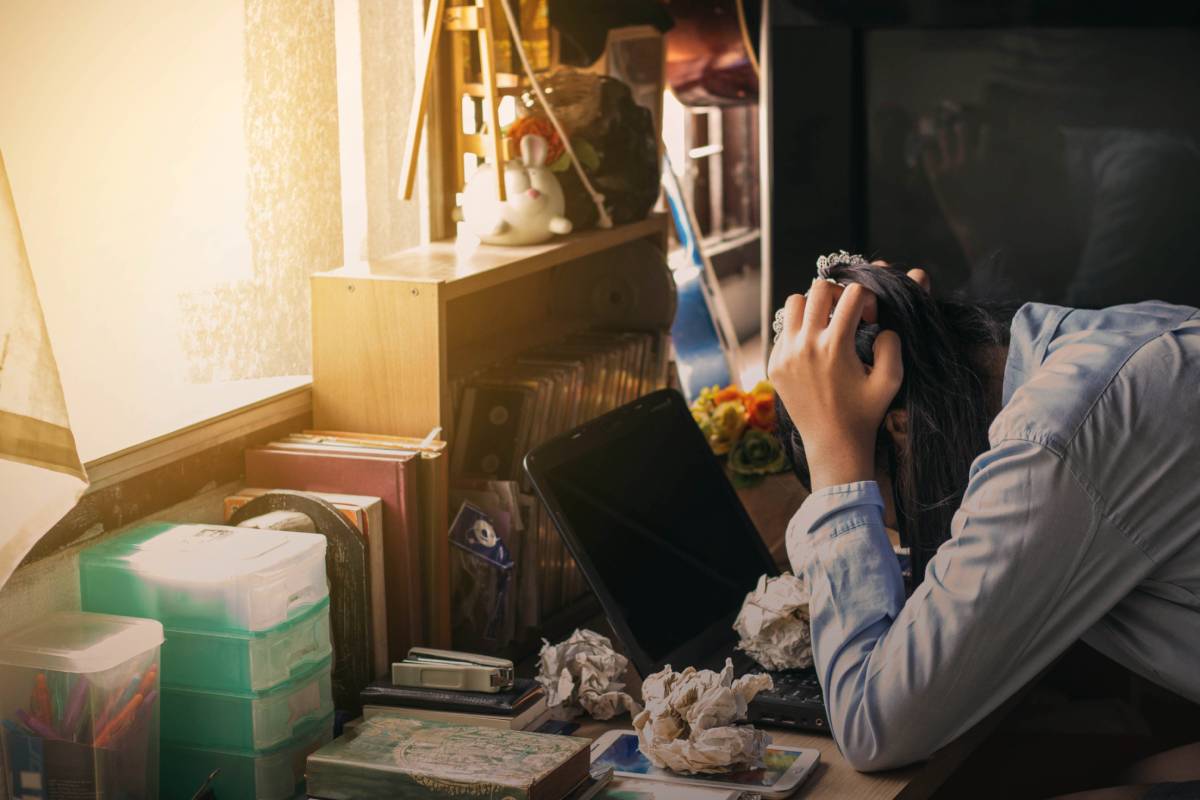 The girl was stressed with work on the table.