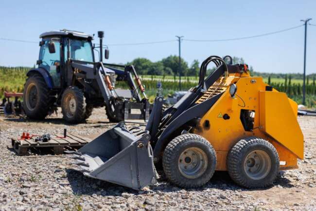 A small tractor with a bucket for moving soil, turf and bulk materials